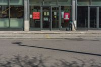 a street sign in front of a glass shop front with many parking spaces in it