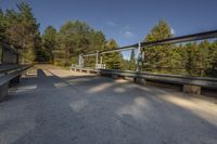 a person is walking across a bridge near a river, with the sun reflecting off of the railing