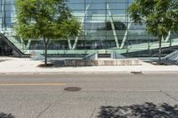 the entrance to an open office building has stairs in front of it and trees by