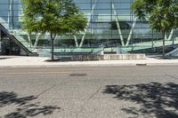 the entrance to an open office building has stairs in front of it and trees by