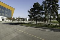 an empty street next to a very large building with many windows on the sides of it