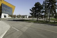 an empty street next to a very large building with many windows on the sides of it