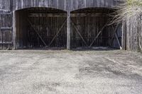 two wooden barn doors are open with hay covering the sides and bottom of it with the grass inside