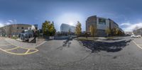 a fish - eye lens photo of a parking lot with buildings in the background with cars