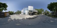 a fish eye view of a building next to trees and a fenced in area