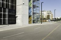 an empty street near tall buildings and a large puddle with a water spout in the middle of it