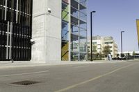 an empty street near tall buildings and a large puddle with a water spout in the middle of it