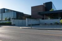 the two buildings have many windows and are next to a parking lot with parking meters