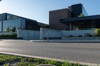 the two buildings have many windows and are next to a parking lot with parking meters