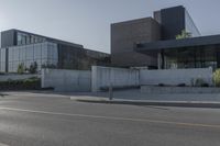 the two buildings have many windows and are next to a parking lot with parking meters