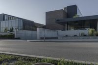 the two buildings have many windows and are next to a parking lot with parking meters