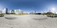 fish eye lens, a panoramic view with buildings in the background and clouds in the sky