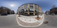 a fish - eye lens picture of a street corner with several buildings on either side of the road