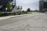 there is a very empty building and its buildings are in the background? with a bench on the side