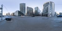 a view of a street filled with cars and tall buildings during the day as seen from an fish eye lens