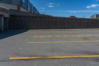 a empty parking lot in a city with no people or cars outside and blue sky