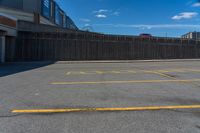 a empty parking lot in a city with no people or cars outside and blue sky