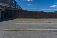 a empty parking lot in a city with no people or cars outside and blue sky