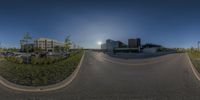 a 360 - view of cars parked on the street at dusk and sun peeking over the buildings