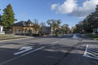 an empty street near a residential residential development with parked cars at a turn around corner