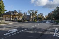 an empty street near a residential residential development with parked cars at a turn around corner