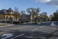 an empty street near a residential residential development with parked cars at a turn around corner