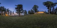 a wide angle view of a house in the country side of the mountains with a lake and trees