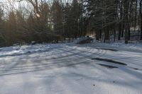 a snow covered ground with some cars in the background and some trees on the other side