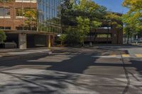 a street view looking down the middle of the road towards a building surrounded by green trees