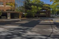 a street view looking down the middle of the road towards a building surrounded by green trees