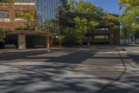 a street view looking down the middle of the road towards a building surrounded by green trees