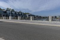 a man walking his bike along a paved walkway with marina homes and buildings on the side in the background