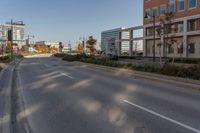 a empty street in a large city with tall buildings behind it and no cars on the road