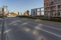 a empty street in a large city with tall buildings behind it and no cars on the road