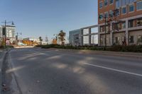 a empty street in a large city with tall buildings behind it and no cars on the road