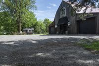 a horse stables is seen here in the summer sun from above the driveway area to the front