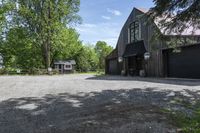 a horse stables is seen here in the summer sun from above the driveway area to the front