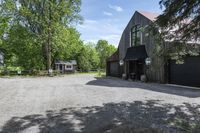 a horse stables is seen here in the summer sun from above the driveway area to the front