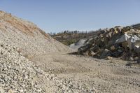 there is a bike rider on a paved dirt road through rocky area near a mountain