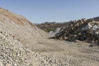 there is a bike rider on a paved dirt road through rocky area near a mountain