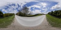 a fish eye lens looking up a hill on the road in the country side of the valley