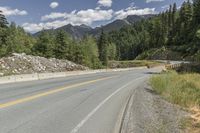 a red triangle is in the middle of the road near the tree line and mountains