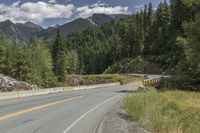 a red triangle is in the middle of the road near the tree line and mountains