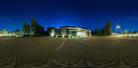 an empty parking lot lit up at night with a circular light structure around the parking