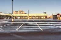 a parking lot filled with lots of white lines and a building in the background from a very cold day