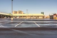 a parking lot filled with lots of white lines and a building in the background from a very cold day