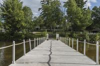 there is a dock with trees in the background at this place, near by water