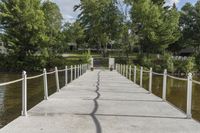 there is a dock with trees in the background at this place, near by water