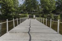 there is a dock with trees in the background at this place, near by water