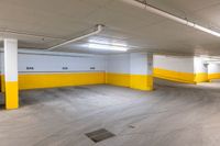 the inside of an empty yellow and white garage with yellow painted walls and ceiling lamps